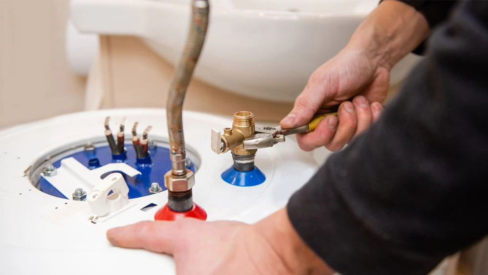Licensed plumber performing a water heater replacement and connecting new water lines for a Utah homeowner